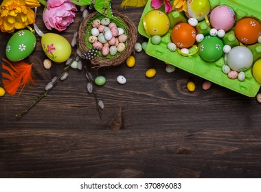 Easter decorations  with colorful eggs and sweet candy over wooden background - Shutterstock ID 370896083