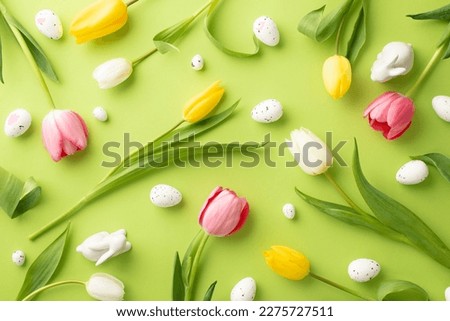 Easter decorations concept. Top view photo of fresh flowers colorful tulips quail eggs and ceramic easter bunnies on isolated light green background