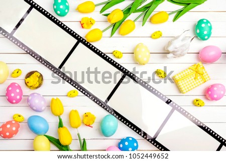 Easter decorations with film tape on white wooden table. Space for text or image. 