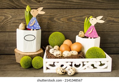Easter decorative composition, home decoration.  On a wooden background, spring flowers, Easter eggs, cute rabbits, Easter eggs, green decorative balls.  The concept of a bright Easter holiday. - Shutterstock ID 2141348567