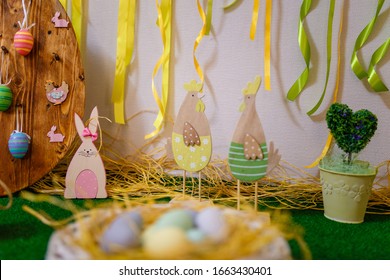 Easter decorative elements, painted eggs, wooden hen, bunny and chicken toys. Soft focused shot.