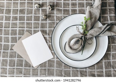 Easter decorative table setting. Spring still life with greeting card mockup, quail and hen eggs. Plates, napkin folding decoration on beige linen table cloth background. Flat lay, top view. Breakfast - Powered by Shutterstock