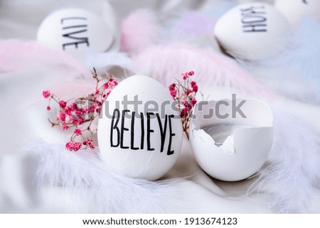 Easter DIY. Do it yourself. Trendy Easter eggs Composition. Easter message, Words drawn with pen. High Angle View Of Shells On Table. Believe. Candle in egg shell. Candle light Pastel colors.