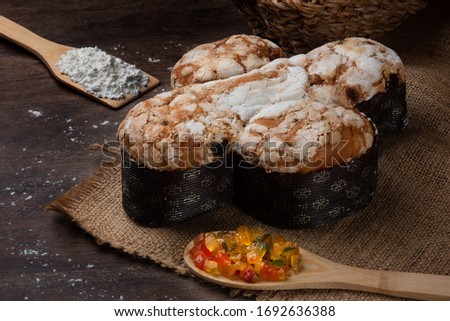 Easter dove bread (colomba Pasquale) made with candied fruits and wheat on a rustic wooden table.