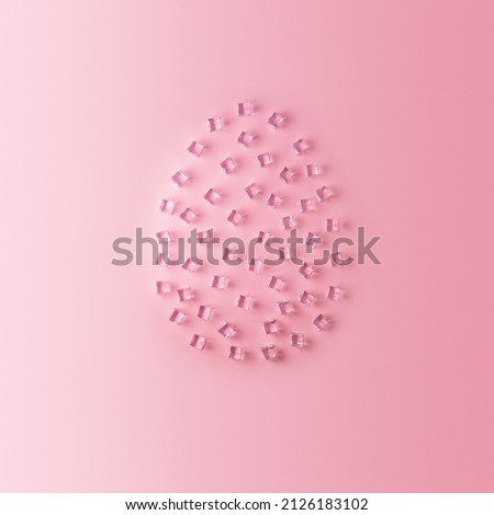 Easter Egg assembled from ice cubes on a pink background with an empty space. 