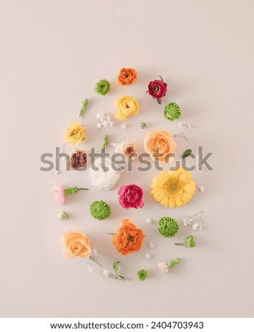 Easter egg frame created of natural flowers on a cream background. Copy space. Nature Holiday concept.