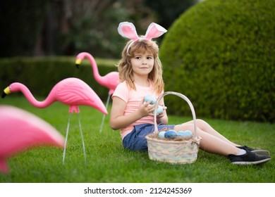 Easter Egg Hunt. Easter Bunny Boy. Child In Bunny Ears Hunting Easter Eggs Outdoor On Backyard.