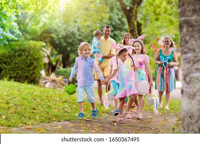 Easter Egg Hunt. Family With Kids Searching For Colorful Eggs. Children Wear Bunny Ears. Boy And Girl With Egg Basket During Spring Holiday. Mother, Father, Son And Daughter Search Sweets.