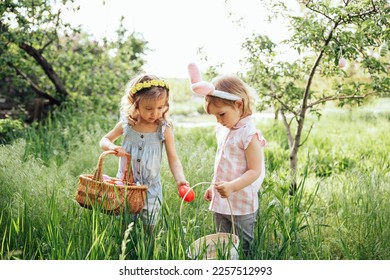 Easter egg hunt. Group Of Children Wearing Bunny Ears Running To Pick Up colorful Egg On Easter Egg Hunt In Garden. Easter tradition