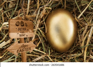 Easter Egg Hunt Sign Against Golden Egg In The Straw