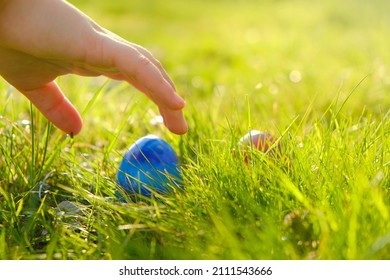 Easter Egg Hunt.Child Hand Collect Eggs In The Spring Garden. Collecting Easter Eggs. Colorful Easter Eggs. Easter Holiday Tradition.Spring Religious Holiday