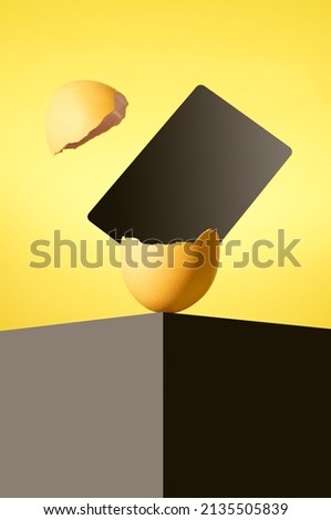 The Easter egg is on a black table.  A black card comes out of the Easter egg. Broken Easter egg.  Happy Easter.