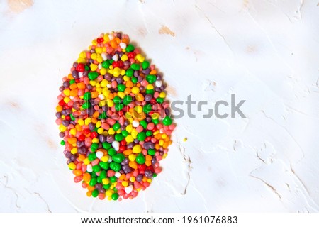 Easter egg shape made of rainbow colored candy nerds. Flat lay. Copy space.