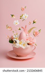 Easter Egg And Spring Flowers In Tea Cup On Bright Pink Background. Creative Easter Holiday Concept. Minimal Greeting Card With Copy Space For Text.