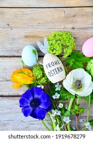 Easter egg with text in German and spring flowers on a rustic wooden background - Frohe ostern means happy Easter - Shutterstock ID 1919678279