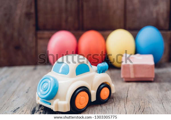 Easter egg and toy car on wooden background,
happy easter day concept