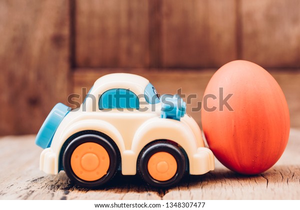 Easter egg and toy car on wooden background,\
happy easter day concept