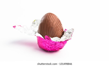 Easter egg unwrapped in pink foil on white background - Powered by Shutterstock