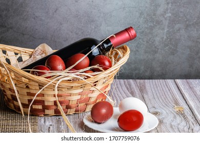 
Easter Eggs In A Basket With Red Wine On A Wooden Table. Preparing For The Light Holiday Easter.
