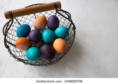 Easter Eggs  In Blue, Turquoise, Purple, And Orange In A Vintage Wire Basket.