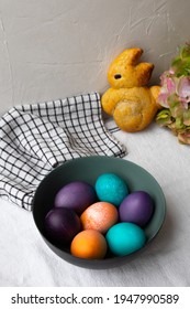 Easter Eggs In A Bowl In Blue, Turquoise, Purple, And Orange, And Brioche Shaped Like An Easter Bunny.