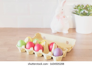 Easter Eggs In Cardboard, Carton, Rabbit, Succulent On The Kitchen Counter, Close Up. Kitchenware In Modern Kitchen Interior. White Tiles Background