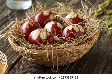 Easter eggs colored with onion peels in a wicker basket on a rustic table