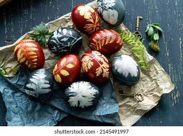 Easter eggs dyed with natural ingredients like cabbage, onion peel, hibiscus tea carcade with beatiful  on rustic wooden tray and craft paper.