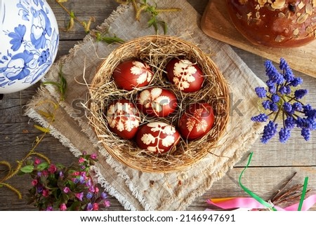 Easter eggs dyed with onion peels with spring flowers and mazanec - traditional Czech sweet Easter pastry, top view