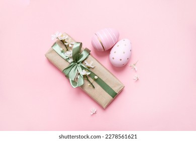 easter eggs , gifts with green ribbon, cherry blossom spring flowers on a pastel pink background. delicate easter layout. copy space. top view. flat lay - Powered by Shutterstock