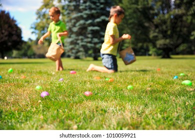 Easter eggs hunting outdoors. children looking for Easter eggs in the grass. blurred background - Powered by Shutterstock