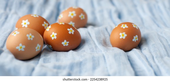 Easter eggs natural color and painted tiny flowers them blue linen fabric  Creative easy idea decorating eggs  Neutral colors  aesthetics  Selective focus 