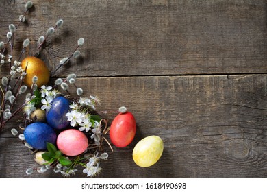 Easter eggs in a nest with willow branches and spring flowers on a gray wooden background. Top view flat lay background. Copy space. - Shutterstock ID 1618490698