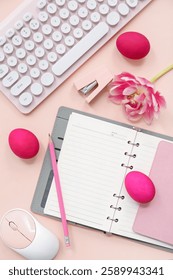 Easter eggs, notebook, flowers, computer keyboard and mouse on pink background