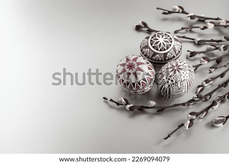 Easter eggs on a silver background with willow twigs