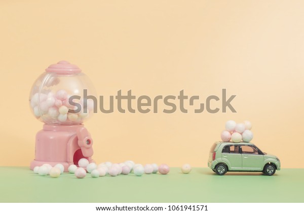 Easter eggs on vintage car\
with  Egg toy vending machine as background.Selective focus\
composition and soft pastel color toned for Easter concept\
background.