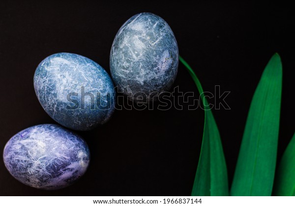 Easter eggs painted in the form of planets in\
space in blue on a black background. Marble dyes for Easter painted\
in hibiscus