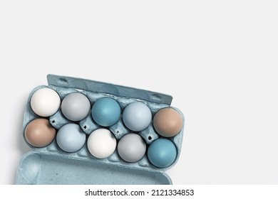 Easter eggs pastel colored in egg box light background and copy space  Minimal Easter celebration concept  dyed chicken egg and color gradient from blue to beige coloured in carton pack  Top view
