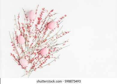 Easter Eggs And Pink Flowers On White Background. Easter, Spring Concept. Flat Lay, Top View.