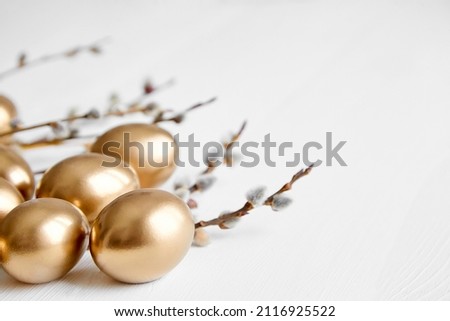 Easter eggs with pussy willow branches on white wooden table happy holiday background
