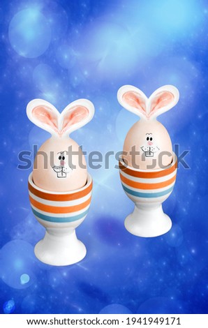Easter eggs with rabbit ears and muzzles on a blue fractal background. The concept of Easter
