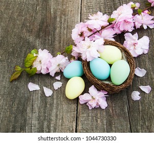 Easter eggs and sakura blossom on a old wooden background