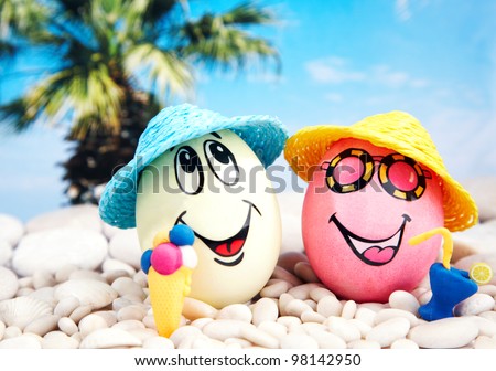 Easter eggs with smile in hats on the beach