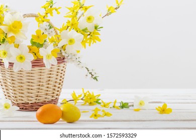 Easter Eggs With Spring Flowers On White Wooden Table