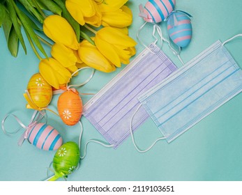 Easter eggs, yellow tulips and a medical mask on a blue background, place for text ER