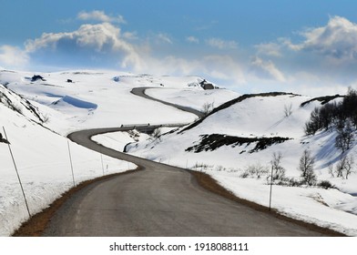 Easter feeling on winding road with nice curves in the snowy mountains of Norway. Road nr fv. 27 Vegabygdsfjellet, Vegabygd mountain, part of the Rondane Norwegian Scenic Route