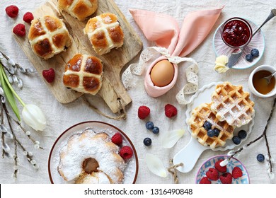 Easter Festive Dessert Table With Hot Cross Buns, Cake And Waffles On Linen Table Cloth. Overhead View