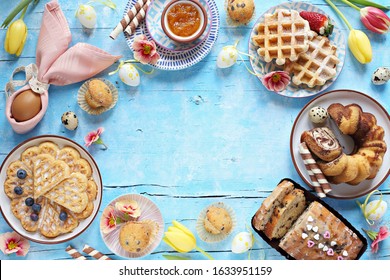 Easter Festive Dessert Table With Various Of Cakes, Waffles, Sweets And Strawberry. Blue Background. Overhead View