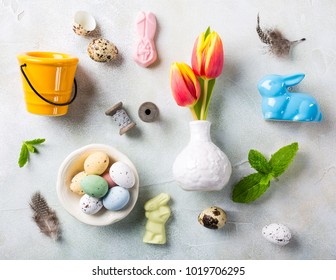 Easter flat lay with orange tulips in white vase, colored quail eggs and spring holidays decorations. Top view. - Shutterstock ID 1019706295