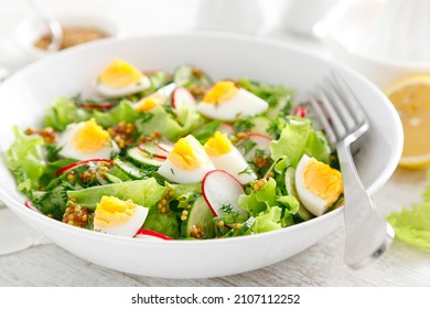 Easter Fresh Vegetable Salad With Boiled Egg, Radish And Cucumber, Dressing With Dijon Mustard And Lemon On White Wooden Table